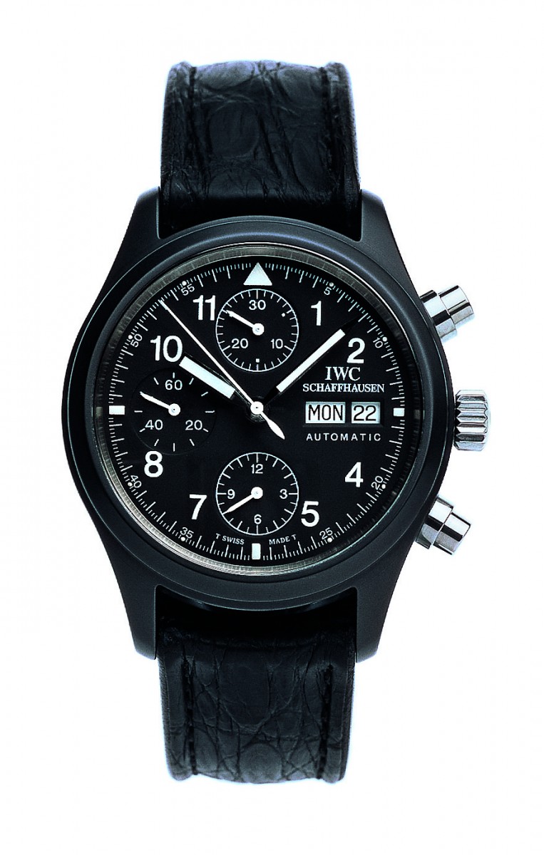 A close macro of a black ceramic IWC watch case next to a raw titanium one, the machined surfaces and finishing clearly visible